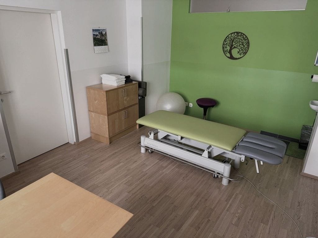Behandlungsraum mit Therapieliege und grüner Wand im Therapie Zentrum Korneuburg